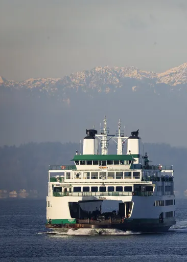 Ferry boat on water with mountains in the background
